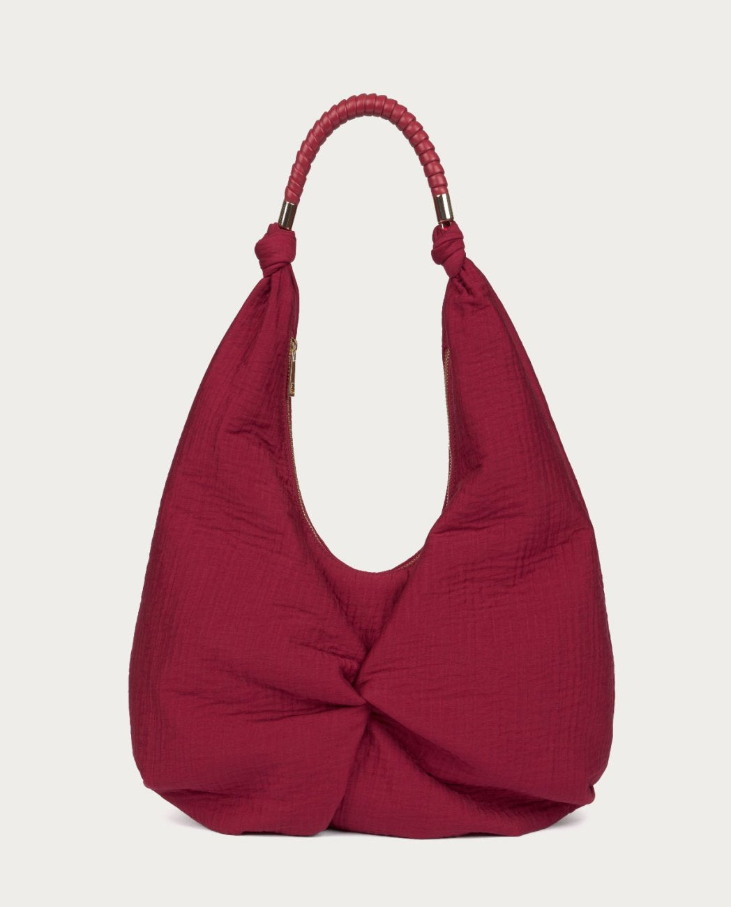 Shoulder fabric red bag with a crinkled finish. It includes a top handle with wraparound detail and decorative metal piece.