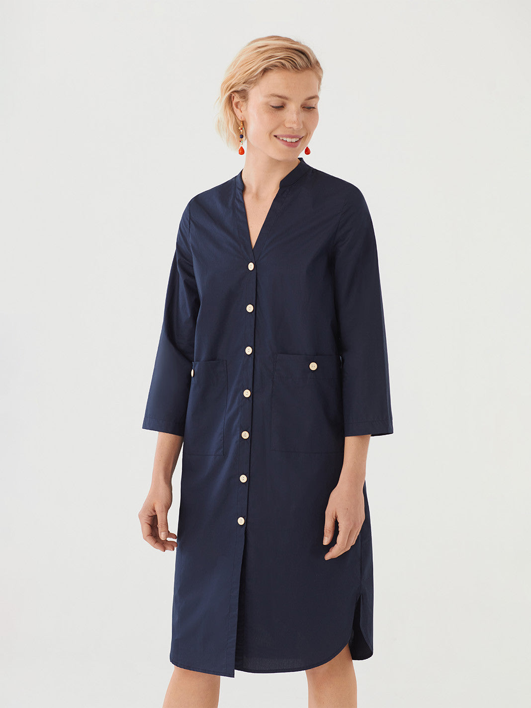 Paper-feel poplin dark blue dress with split detail. Mandarin collar and front coconut buttons. Front patch pockets with coconut buttons. Three-quarter sleeves. Composition: 100% Cotton