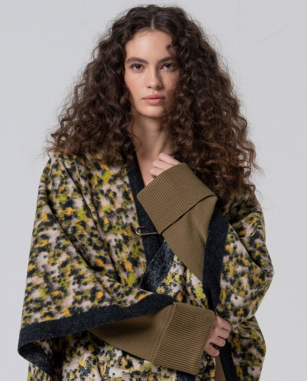 animal print poncho in light green, yellow, ecru and black colors and pin closure