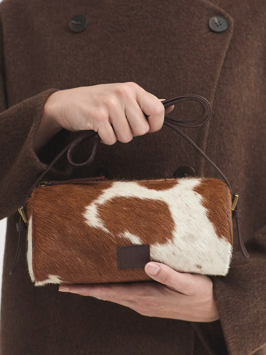 Printed baguette bag in 100% pony hair with a zip top fastening and an adjustable strap with buckles. Animal print in brown and ecru colors, 23 cm long x 11 cm high x 10 cm deep.