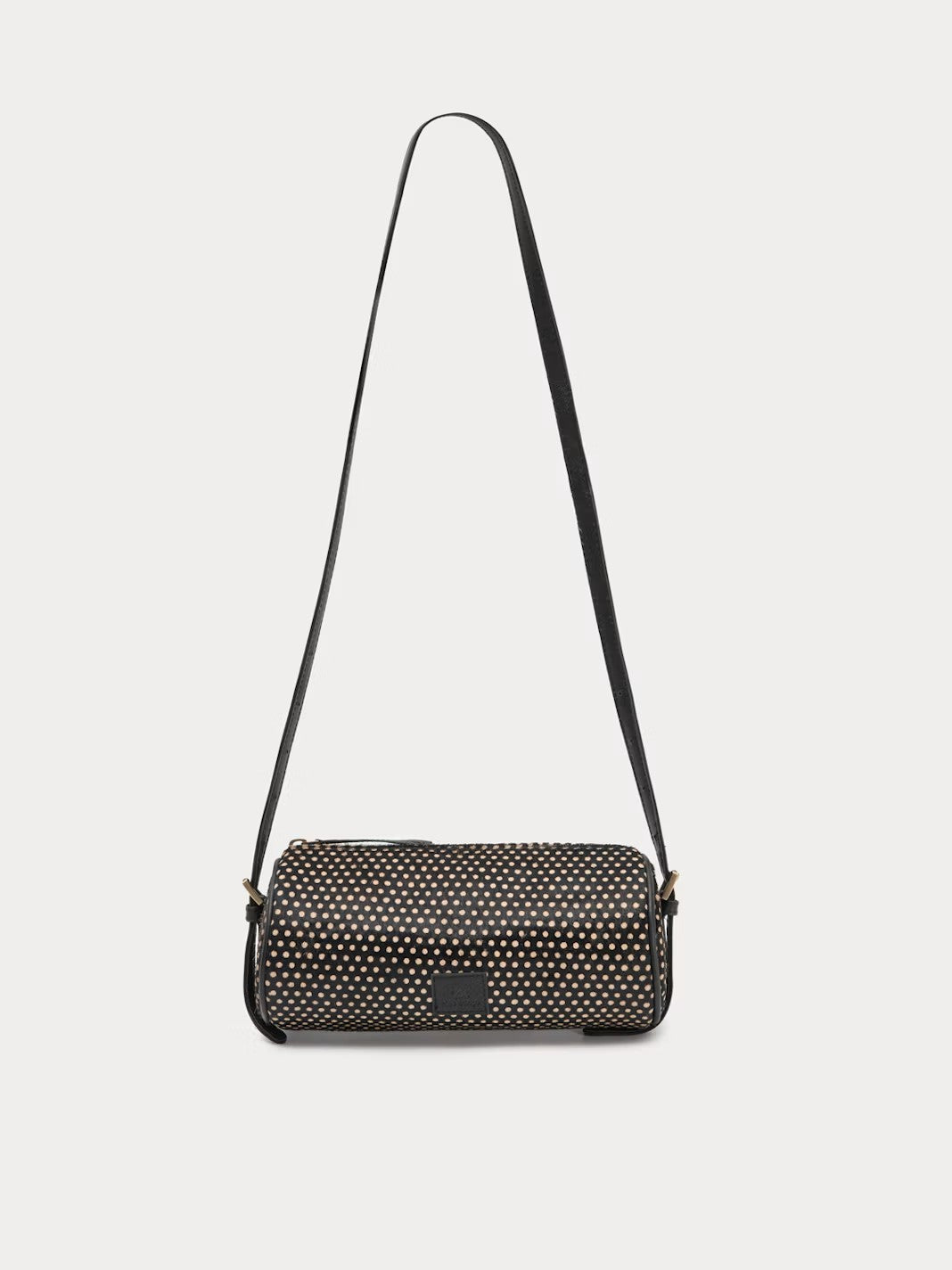 Printed baguette bag in 100% pony hair with a zip top fastening and an adjustable strap with buckles. Polka dots print in black and beige colors, 23 cm long x 11 cm high x 10 cm deep.
