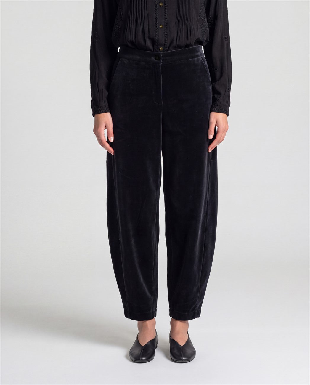 Cotton velvet black trousers with a rounded barrel leg and a high waist. Button-and-zip fastening, pockets and a soft, warm feel.