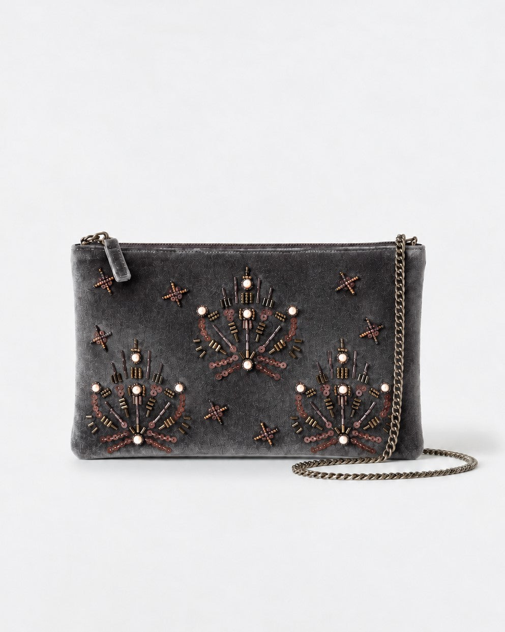 Flat brown clutch hand-embroidered with beads, bugle beads and pearls tracing jewel motifs and stars. Soft velvety viscose fabric, with a detachable chain strap and wrist loop. Inner pocket. 27,5cm x 17cm x 1cm