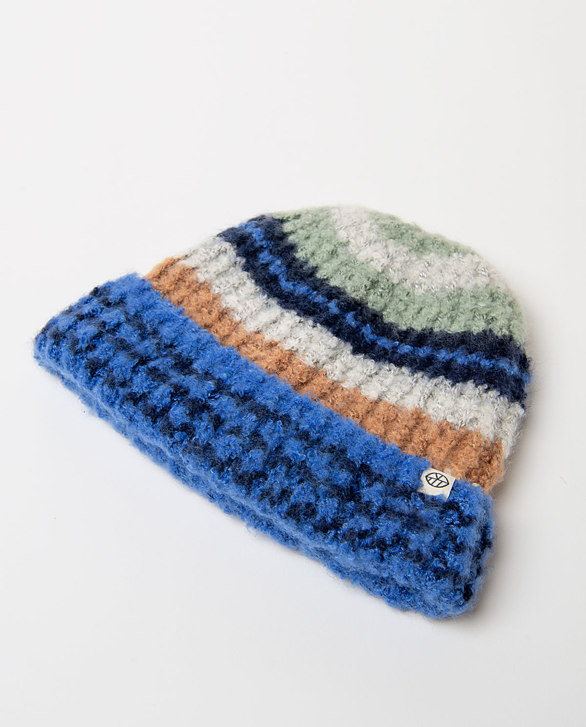 Chunky blue knit beanie with a wide contrast turn-up and bouclé texture. The top features warm multicolored jacquard stripes.