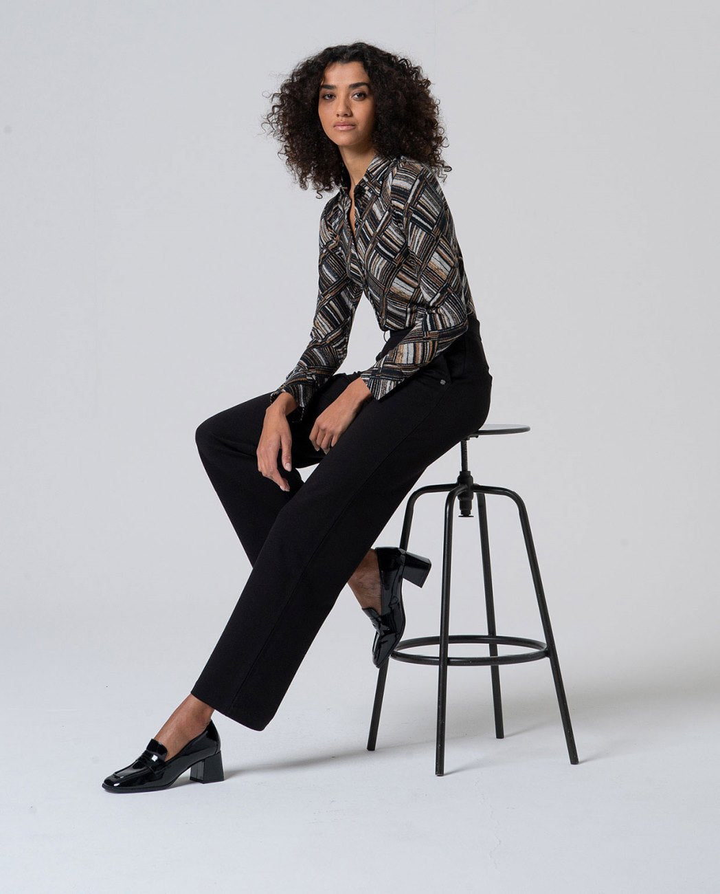 Straight black pants without zippers, with pockets and decorative button detail at the waist that mimics a belt, in 56%Rayon, 37%Nylon, 7%Spandex