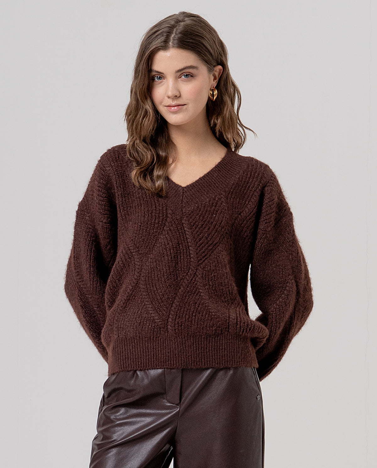 V-neck chocolate jumper with long sleeves, in soft knit with wool and a diamond cable texture. Warm, cosy with a relaxed cut and dropped shoulders.