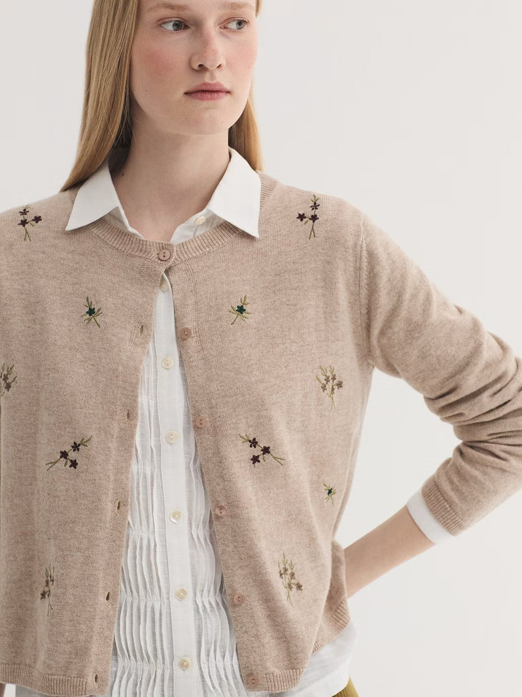 Embroidered beige cardigan in wool and cashmere blend, with round neck and long sleeves. Ribbed finish.