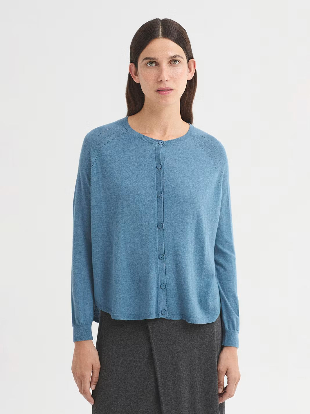 Cape style light blue cardigan in merino wool cashmere blend with round neck and raglan sleeves. Ribbed finish.