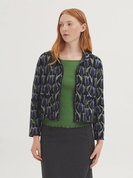 Short navy blue jacquard jacket with tulip design, in light green, ecru light blue colors, shirt collar, front patch pockets and long sleeves.