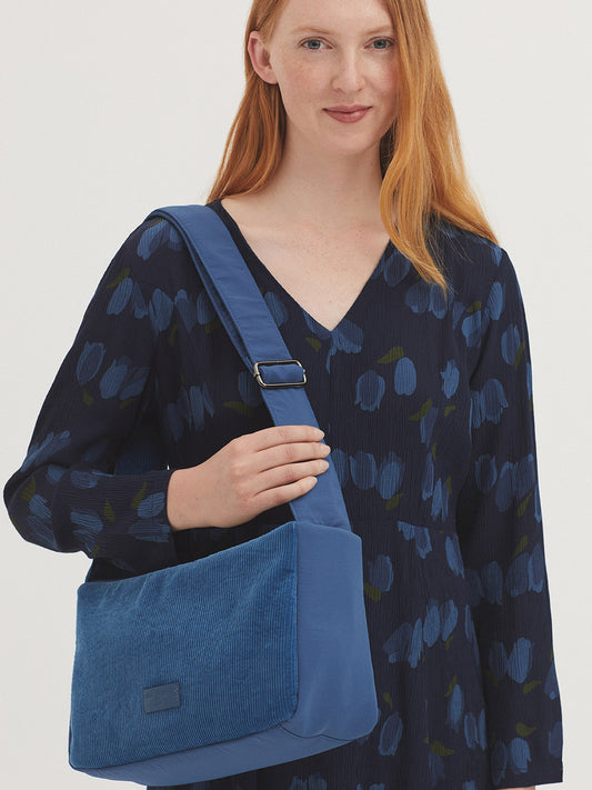 Large crossbody bag made of corduroy and nylon, with adjustable strap, zip top fastening and pull tab with logo, inside pockets.