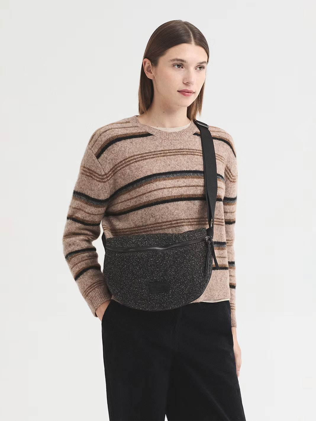 Curved crossbody grey bag in two-tone bouclé with an adjustable strap. Featuring a zip top fastening with a double zipper pull and an inside pocket. The design is finished off with a logo patch, 26 cm long x 18 cm high x 7 cm deep.