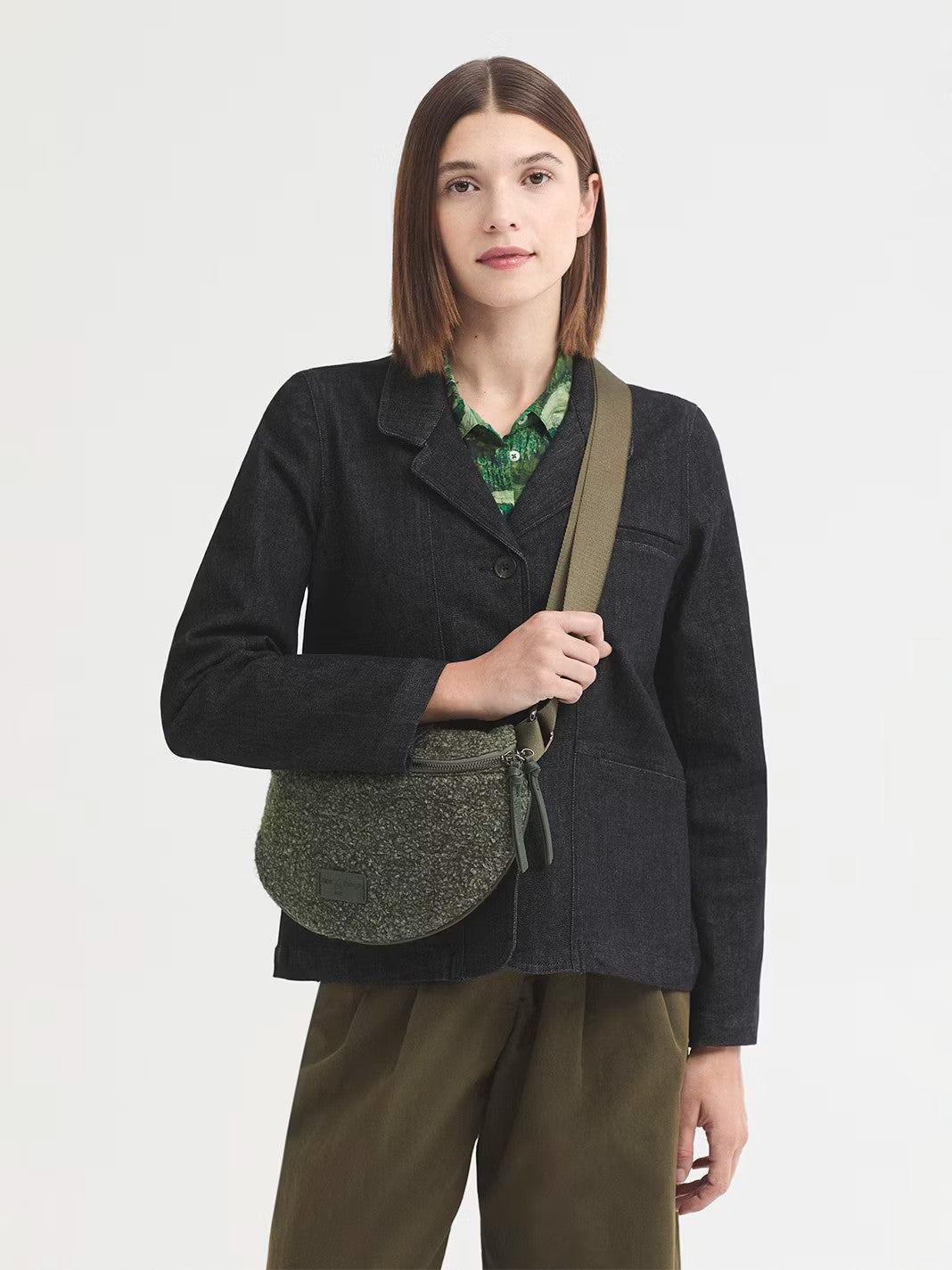 Curved crossbody khaki bag in two-tone bouclé with an adjustable strap. Featuring a zip top fastening with a double zipper pull and an inside pocket. The design is finished off with a logo patch, 26 cm long x 18 cm high x 7 cm deep.