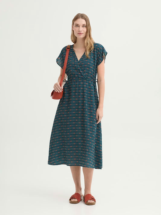 Mesh-knit fabric blue dress with Hellenic Waves print, in white stripe waves and red dots, crossover V neck, ties at the sides of the waist for cinching, side pockets and flared skirt, in 50% Viscose, 50% Cotton.