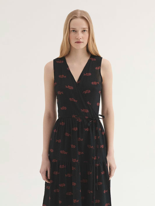 Mesh-knit fabric black dress with Ithaca Fish print, in orange and mauve colors, wrap dress with self-fabric tie waist, V neck, natural waist, ruffle skirt and side pockets.