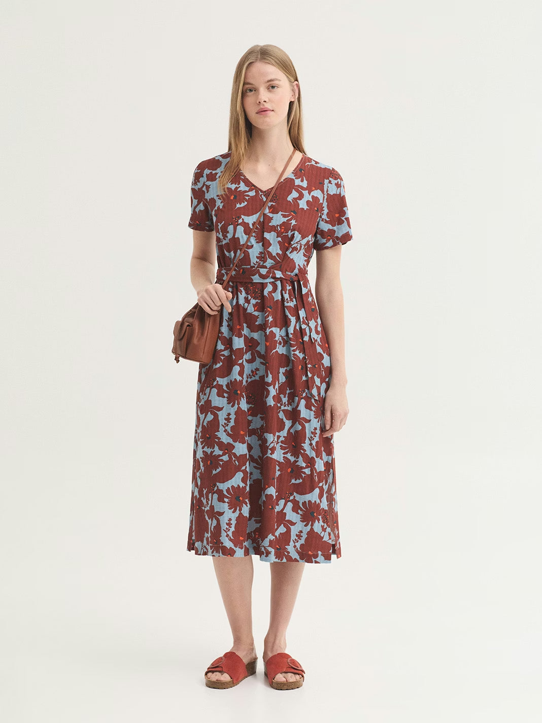 Dress in sustainable viscose fabric, Penelope Flowers print, in chestnut color with navy and orange small dots on turquoise background color, natural waist, self-fabric tie waist for cinching and side splits at hem.
