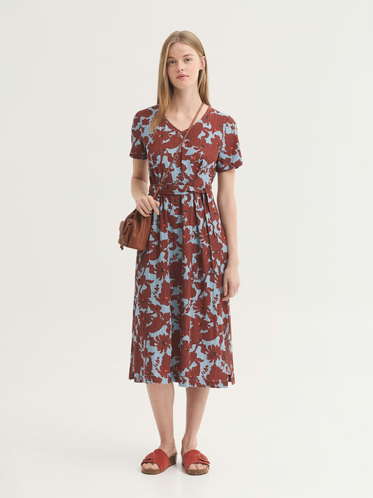 Dress in sustainable viscose fabric, Penelope Flowers print, in chestnut color with navy and orange small dots on turquoise background color, natural waist, self-fabric tie waist for cinching and side splits at hem.