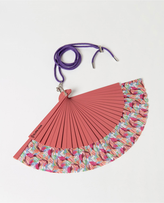 Red hand fan with floral edge and purple strap.