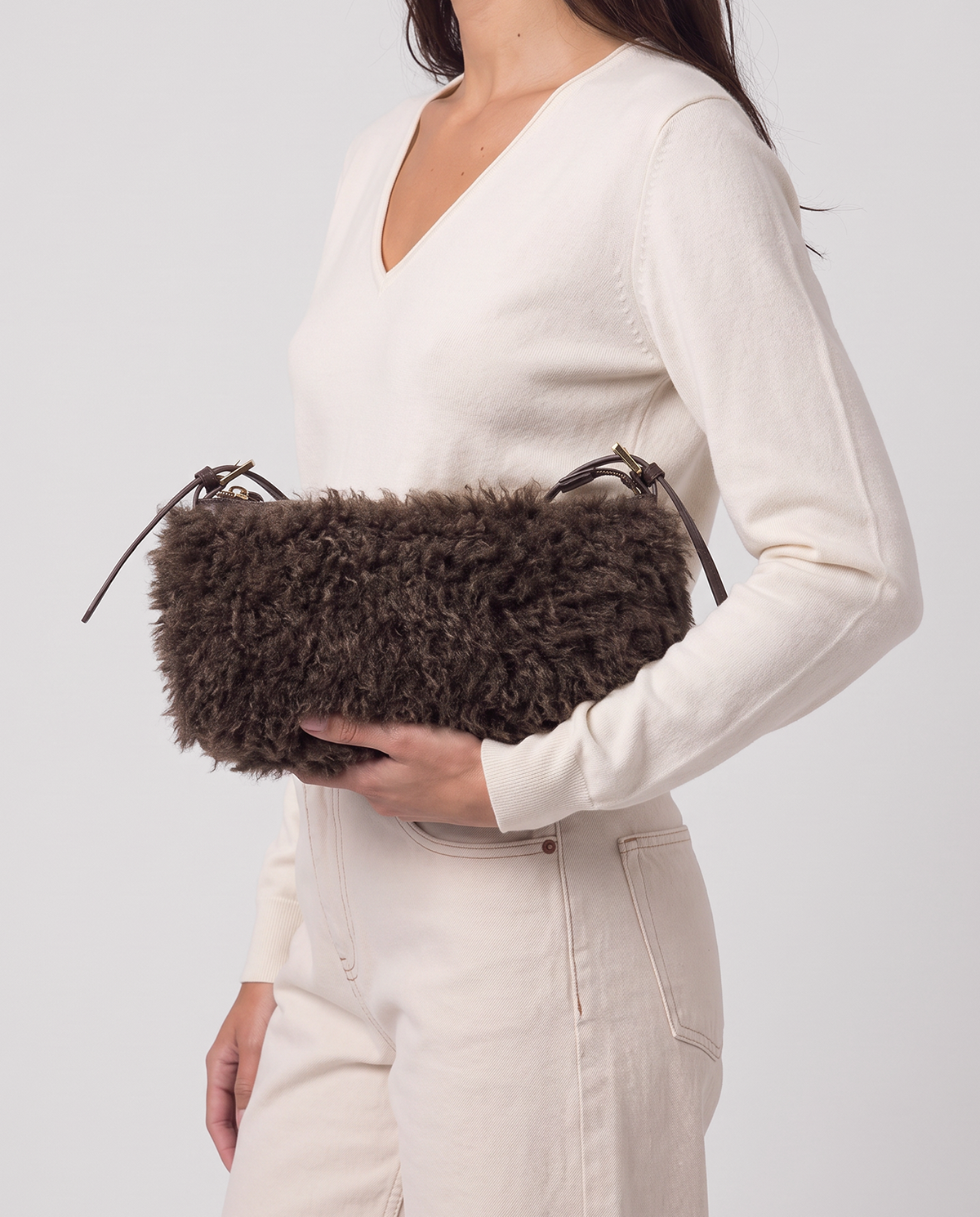 Baguette brown bag in long-pile faux fur with a plush feel. Small, elongated shape with a thin adjustable strap and zip closure, 28cm x 16cm x 7cm