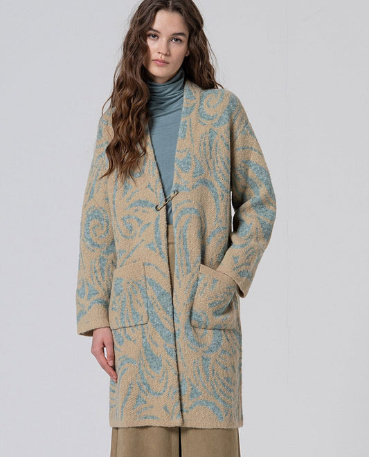 Long chunky knit coat with swirl light blue and beige jaquard print, with decorative buckle closure,  patch pockets and a kimono-like structure, in 50% Polyester, 30% Wool, 20% Recycled Polyester.