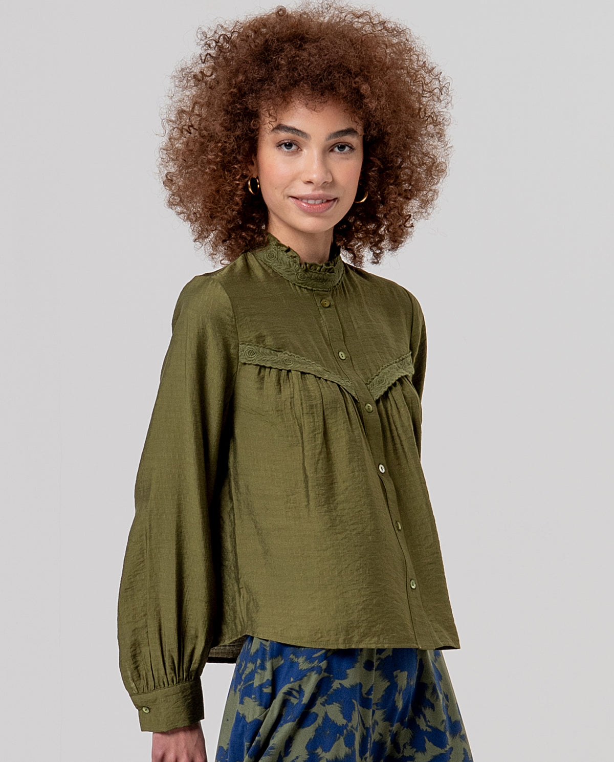 Fluid khaki viscose shirt with a high neck and front button placket. Gathers at the top and a guipure lace trim, a romantic detail. Light fabric with a soft drape.