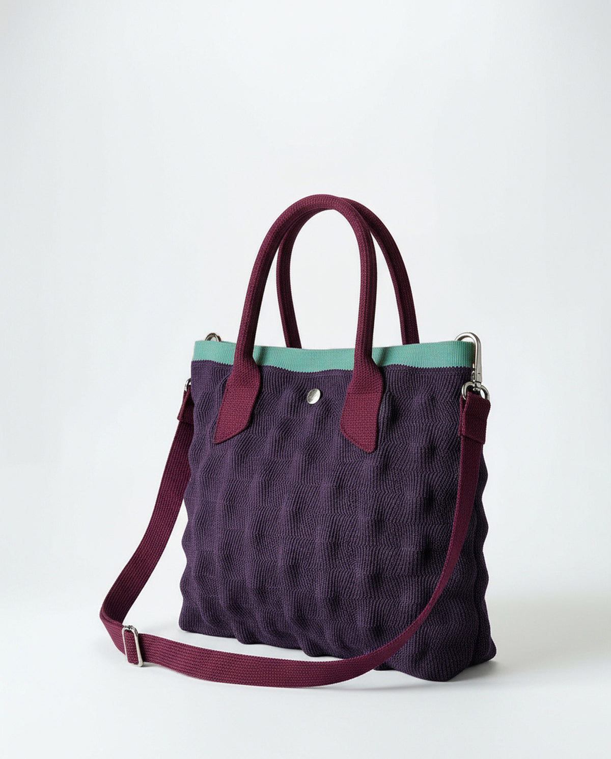 Mini purple knit shopper with a bubble-effect 3D texture. Two short handles and an adjustable - removable crossbody strap, with contrast trim in meant color and a zip closure. 24cm x 19cm x 6cm