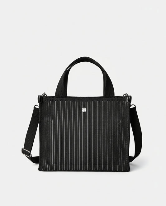 Mini black shopper in fine vertical striped knit, light and flexible. Double handles and adjustable crossbody strap, with a top closure and metal charm. Inner pocket. 24cm x 19cm x 6cm