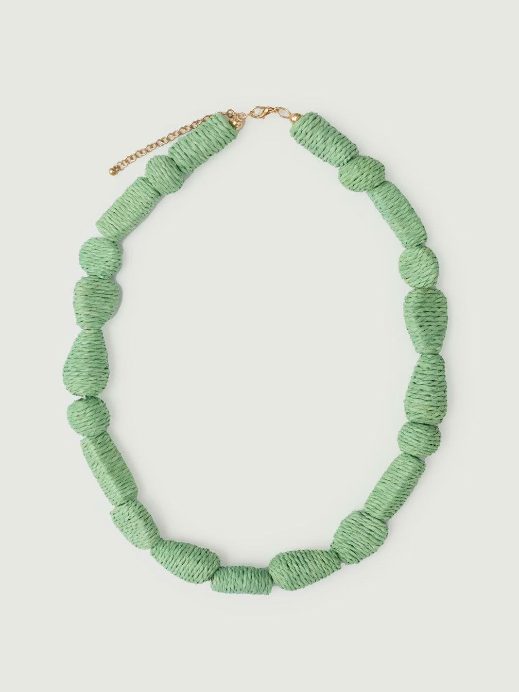 Geometric beads necklace made of raffia, mint color, adjustable bronze closure, 26 cm in length.