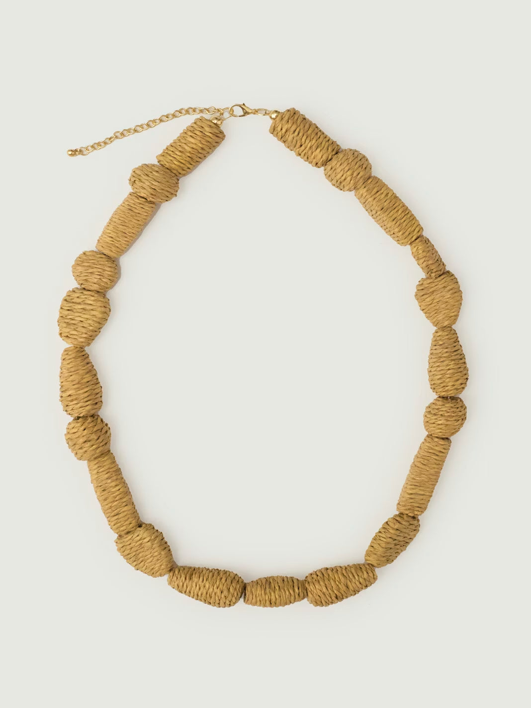 Geometric beads necklace made of raffia, nature color, adjustable bronze closure, 26 cm in length.