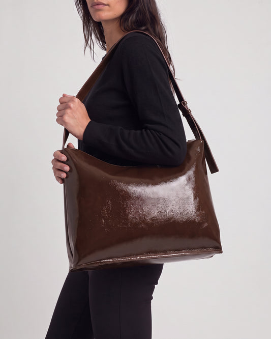 Shoulder chocolate bag in high-shine patent with a smooth feel. Triangular, unstructured shape with a soft drape, thin adjustable strap and zip closure. Inside patch pocked and zip closure pocked, 30cm x 40cm x 1cm