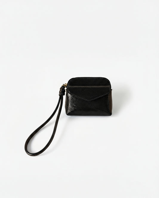 Coin purse black in crinkled patent with an intense shine. Envelope flap and zip closure, with a handy wrist strap. Mini, light format for the essentials. 10cm x 8cm x 2cm