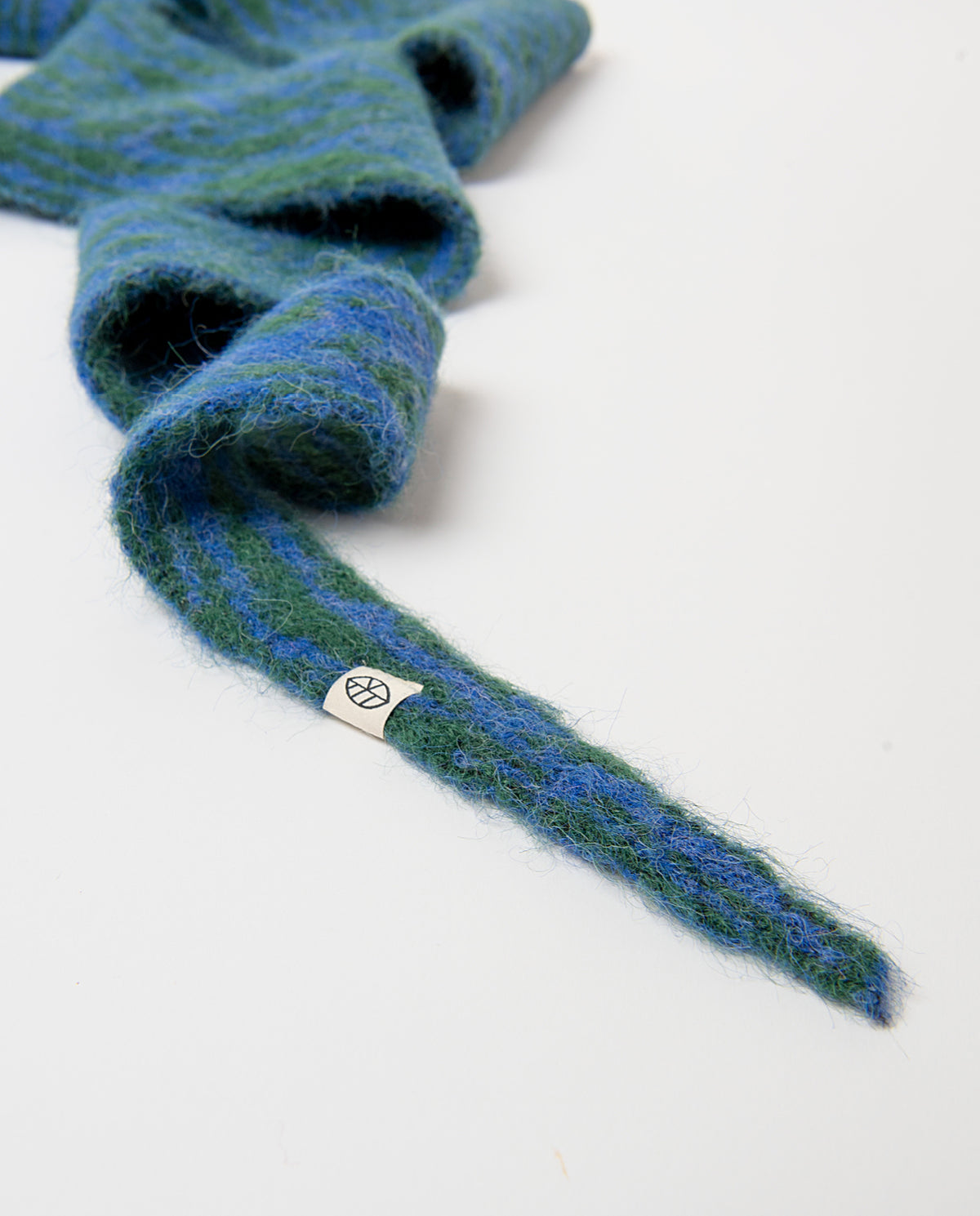 Knit bandana in recycled polyester with a two-tone blue and green jacquard motif, soft and fluffy to the touch. Pointed ends that tie around the neck, 170cm long, 20cm wide