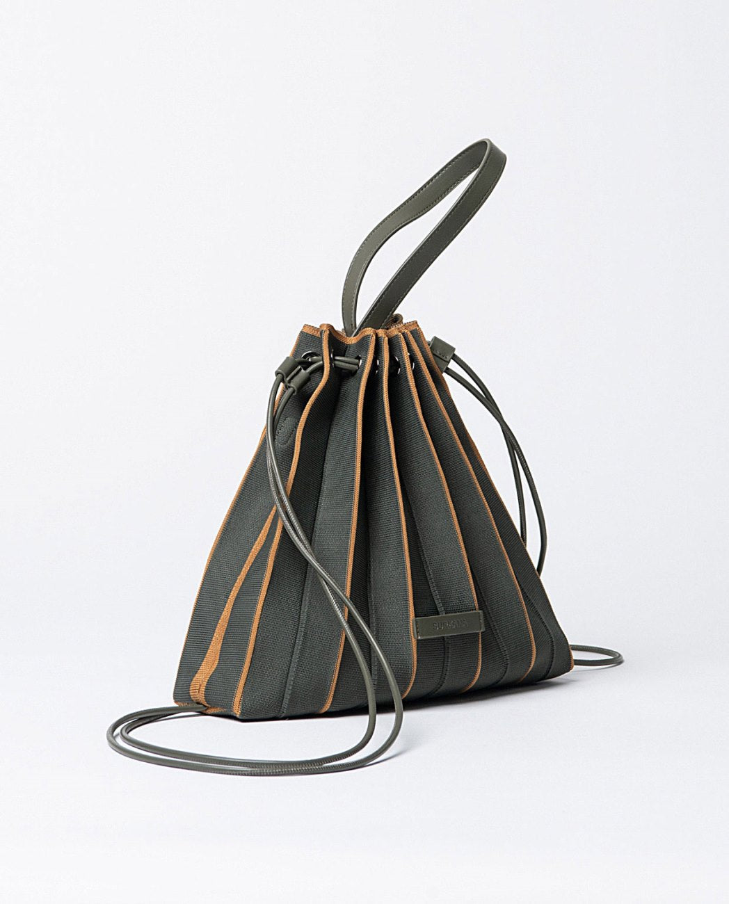 Knitted pleated backpack-bag in khaki and orange colors, closure with cords that slide through eyelets, includes a practical zippered toiletry bag and removable shoulder strap.