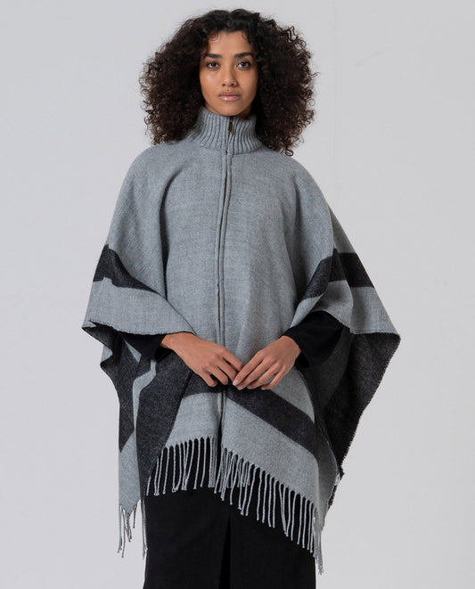 Wide cut and knit grey poncho with zipper front closure and stand-up collar. It features a design with black contrasting  stripes and long bangs