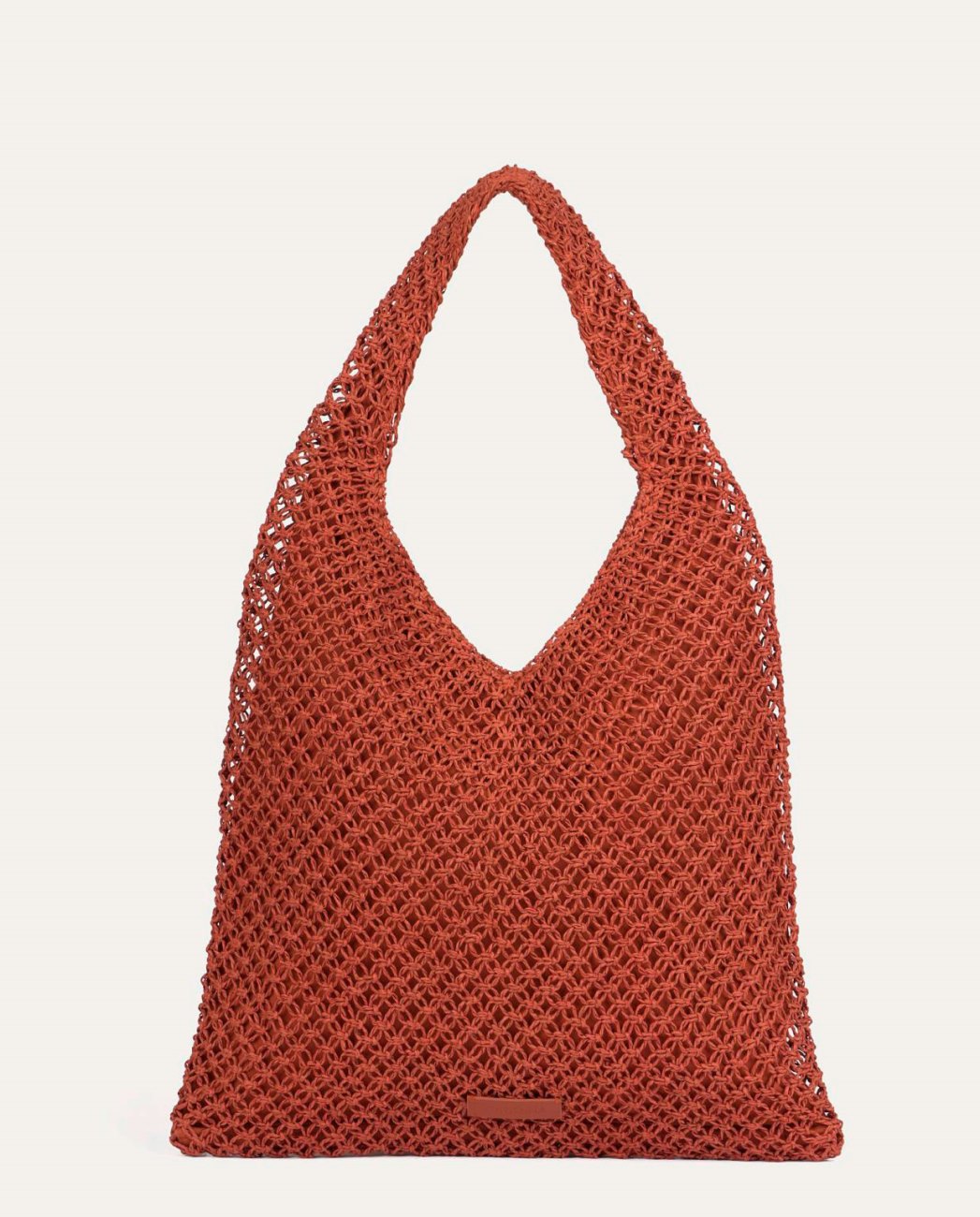 Coral shoulder bag made of hand-woven raffia paper.