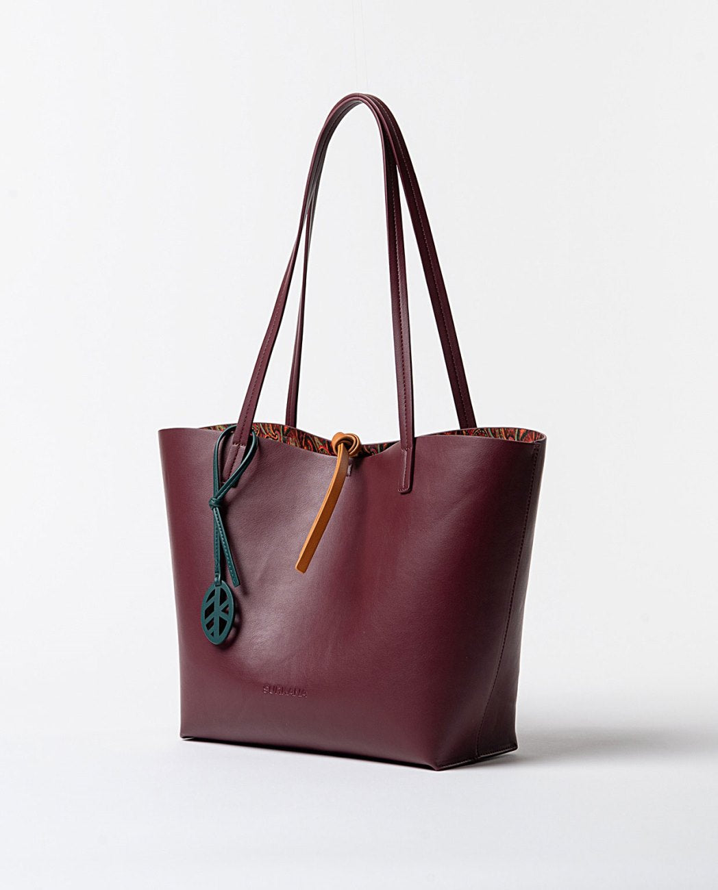 Large reversible faux leather shoulder bag  with printed toiletry bag,on one side,bordeaux color and on the other, an original print in bordeaux, green. orange colors.