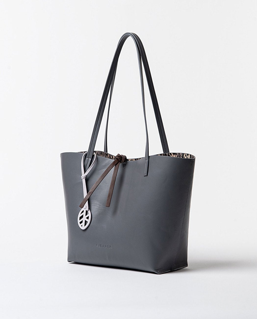 Large reversible faux leather shopper bag with printed toiletry bag, on one side, grey color and on the other, an original print in brown, grey and ecru colors.