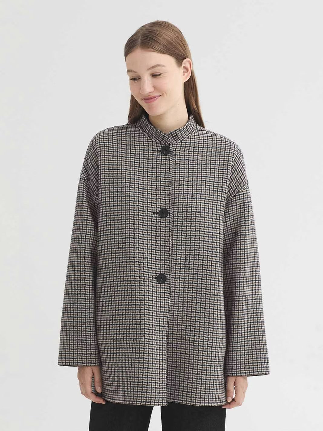 Reversible jacket in double faced wool blend fabric, with a check side and a plain side. With a mandarin collar, centre button front, in-seam pockets on the check side and patch pockets on the plain side.