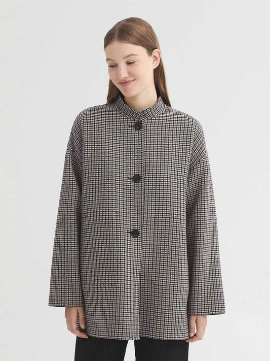 Reversible jacket in double faced wool blend fabric, with a check side and a plain side. With a mandarin collar, centre button front, in-seam pockets on the check side and patch pockets on the plain side.