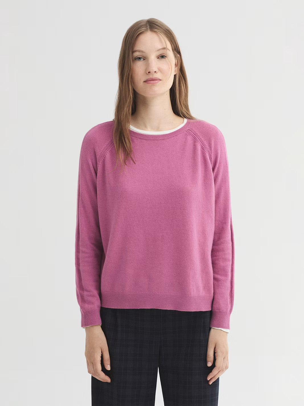 Basic pink raglan jumper in wool and cashmere blend with knit detail on armholes en sleeves. Round neck and long sleeves. Side splits at the hem and ribbed finish.