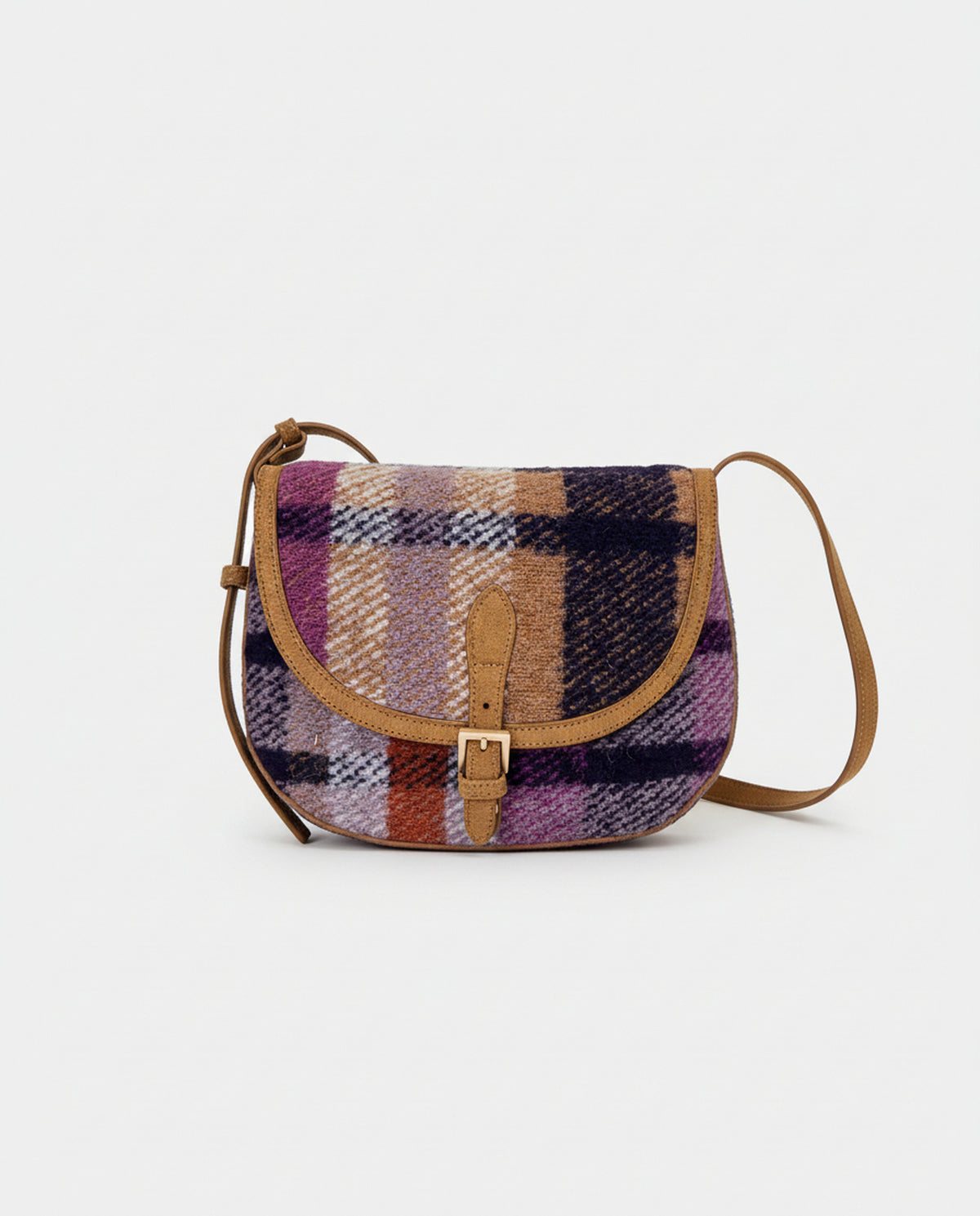 Saddle-style crossbody bag with a curved flap and buckle closure. Body in warm, textured purple wool check fabric, with camel suede-effect trims. Adjustable strap. Inner open pocket and zip pocket, 26cm x 20cm x 2,5cm