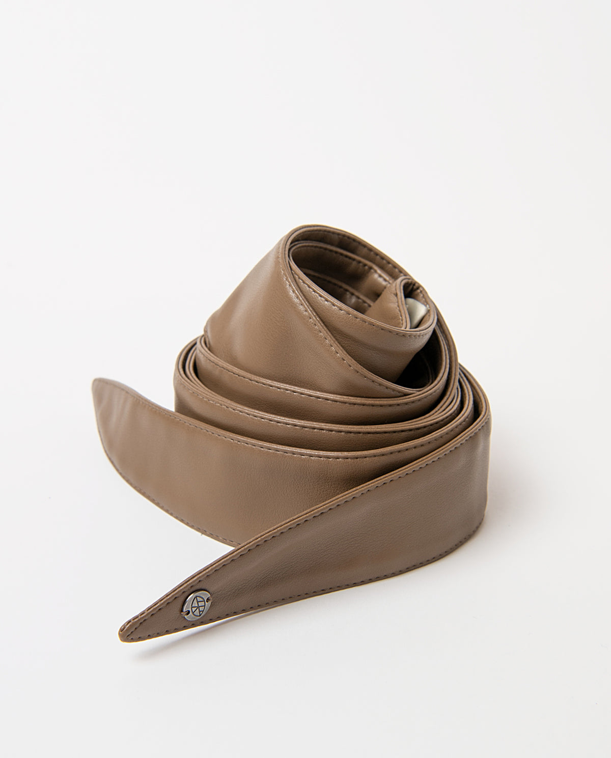 Sash-style light brown belt in smooth faux leather, wide and soft to the touch. Pointed ends that tie in a bow, no buckle, with a branded metal rivet.220cm long, 4,50 - 12,50cm wide