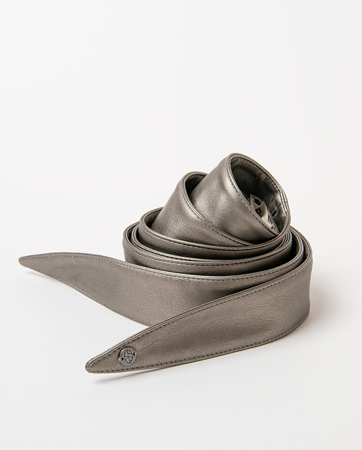 Sash-style silver belt in smooth faux leather, wide and soft to the touch. Pointed ends that tie in a bow, no buckle, with a branded metal rivet.220cm long, 4,50 - 12,50cm wide