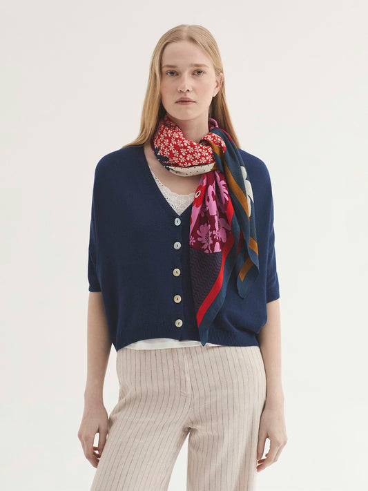 Penelope square navy print scarf. In the center the figure of Penelope with long wavy hair, surrounded by colorful flowers and symbols, 57% Modal, 43% Cupro, 90 x 90 cm