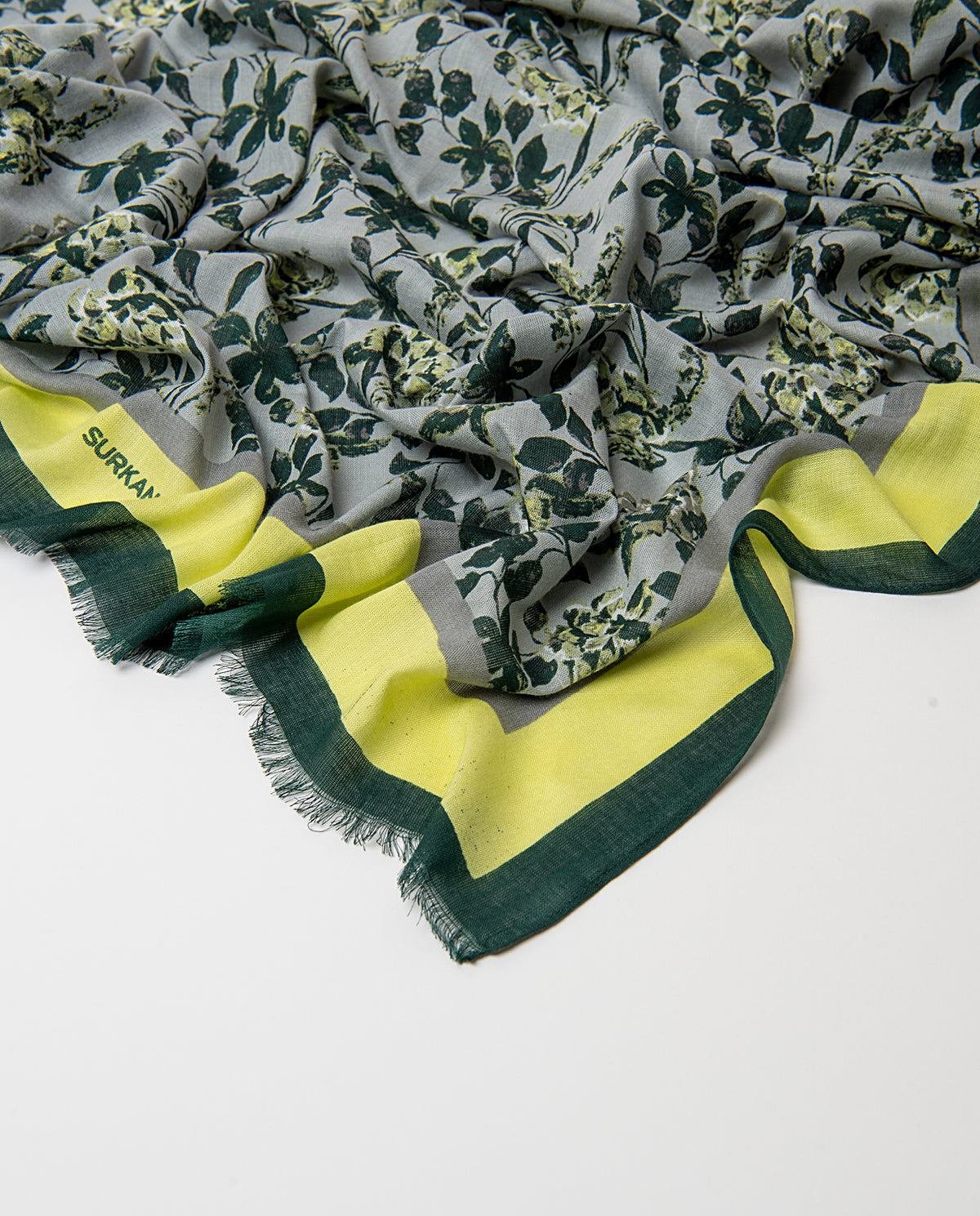 Rectangular light grey scarf in light viscose with soft drape. Delicate dark green, white yellow roses print on a light background, with a contrasting banded border and fringe.