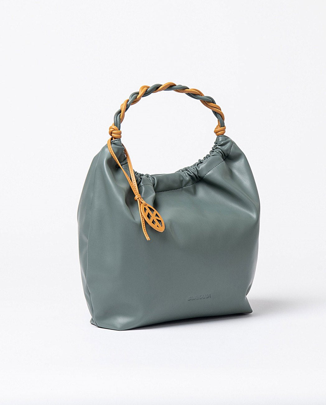 Large faux leather steel blue shoulder bag with short bicolor braided handle and decorative charm in yellow color, closure with magnet button, interior with two compartments (one with zipper and one without) and a removable toiletry bag with zipper closure.