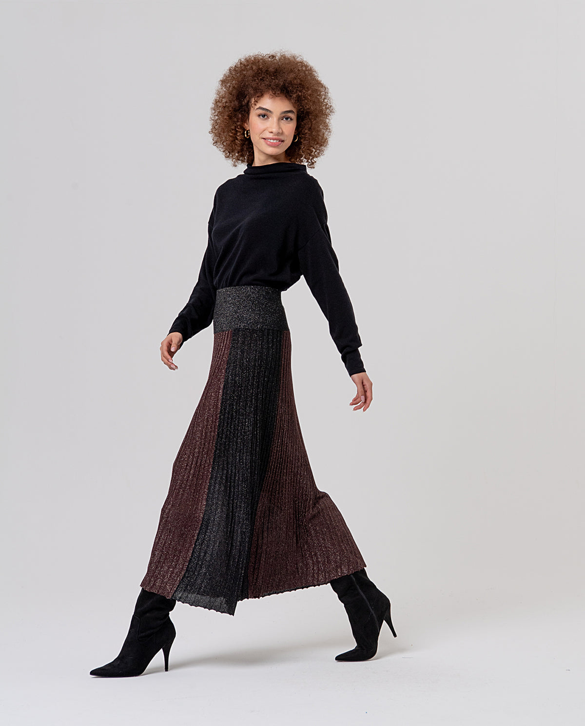 Pleated midi skirt with a lurex shimmer and elastic waist. Colour-block design pairing a central brown panel with darker black side sections.