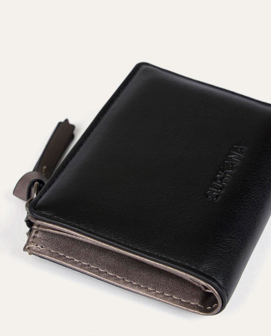 Black small wallet with inside metallic color and zipped compartment.