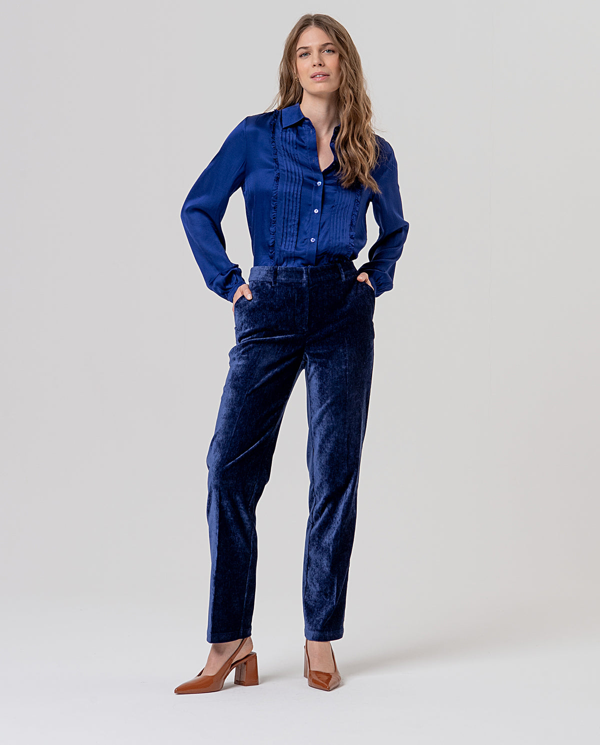 Straight-leg navy high-waisted trousers with belt loops and pockets, in velvet fabric with a soft feel and subtle sheen. Clean, flattering silhouette. 