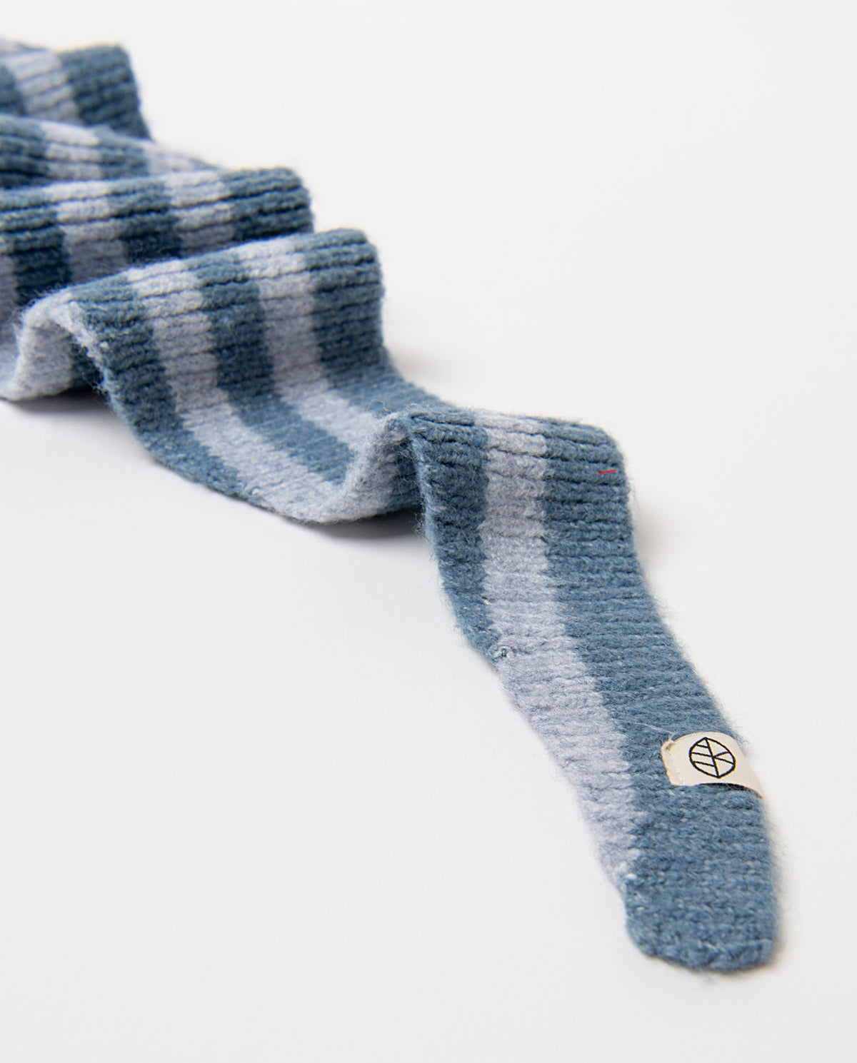 Ribbed knit bandana in recycled polyester, with contrast dusty blue and light blue stripes and a triangular shape. Soft and cosy, it ties around the neck in one gesture, 121cm long, 18cm wide