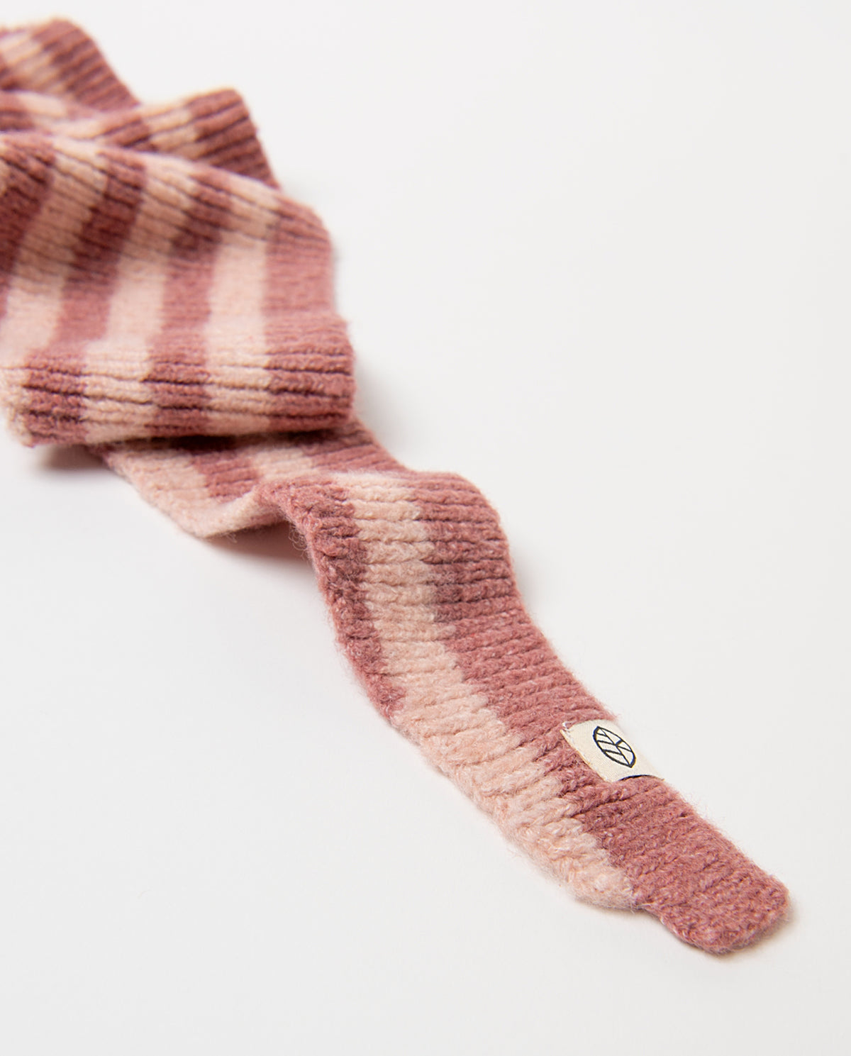 Ribbed knit bandana in recycled polyester, with contrast stripes in pink and dark pink in a triangular shape. Soft and cosy, it ties around the neck in one gesture, 121cm long, 18cm wide